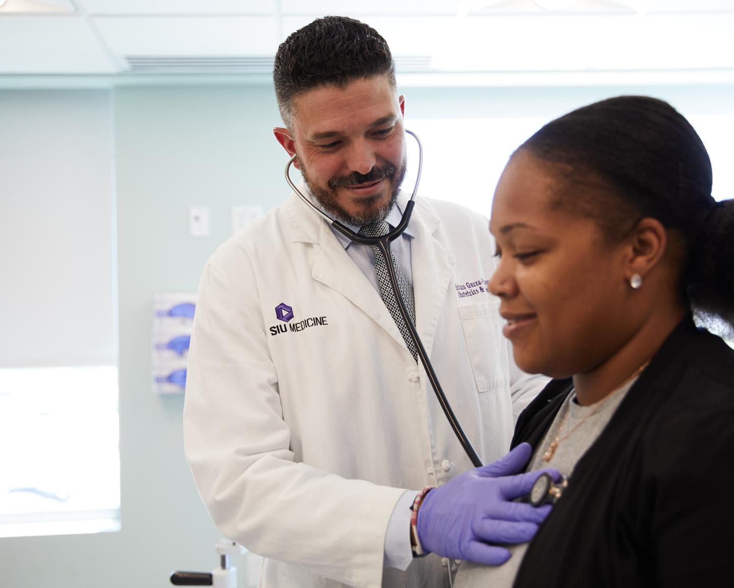 OB-GYN listens to a patient's heart